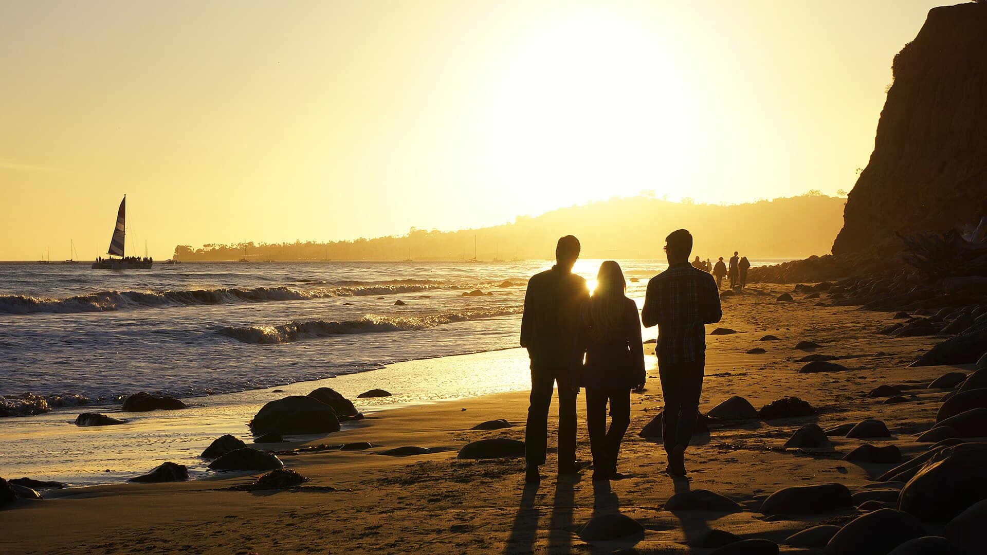Friends walking along the shoreline at sunset