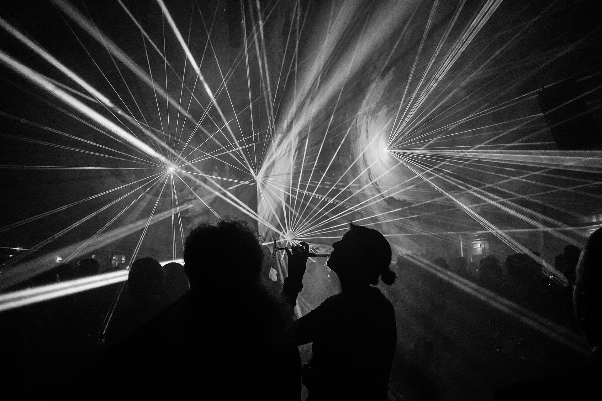 Laser light show over a crowd — atmospheric stand-in, not an event photo